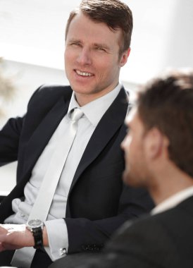 bir masanın arkasında oturan arkadaşı ile başarılı iş adamı.