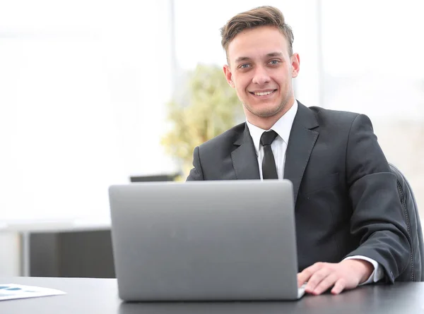Jovem empresário trabalhando no laptop no local de trabalho — Fotografia de Stock