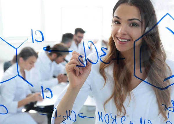 Smiling female assistant makes an entry on the Board. — Stock Photo, Image