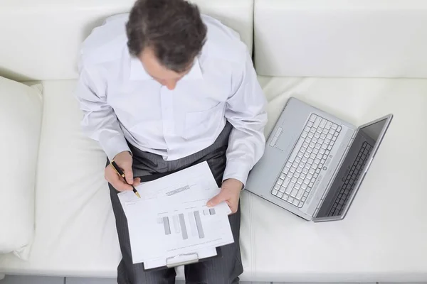 view from the top.businessman working with documents sitting on sofa