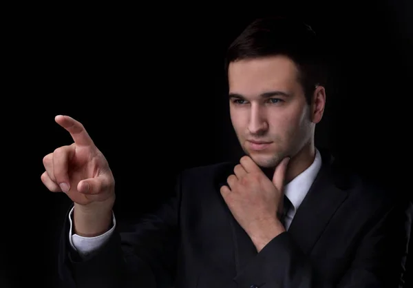 Businessman pointing to a blank spot.isolated on a black background. Stock Image