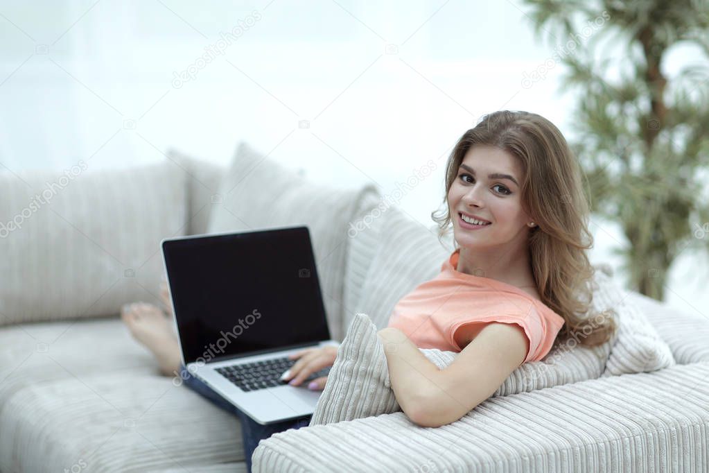 young woman working with laptop sitting in the living room