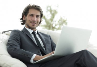 işadamı bir şık rahat chai oturan bir dizüstü bilgisayar ile