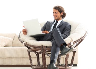 şık rahat sandalyede oturan bir dizüstü bilgisayar ile modern iş adamı