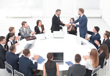 iş ortakları yuvarlak masa yakınındaki müzakerelerinde el sallamak