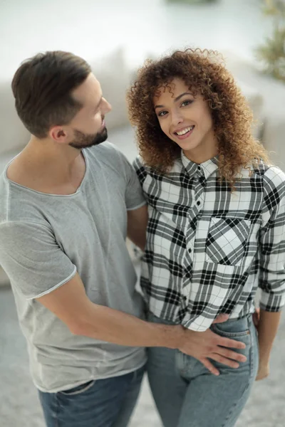 mutlu genç çift birbirlerine sarılıyor.