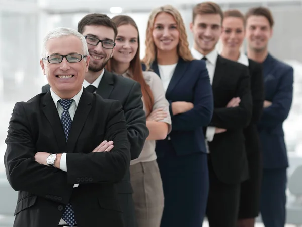 Senior obchodník stojící před jeho obchodního týmu — Stock fotografie