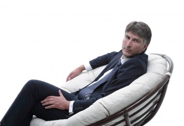 yan görünümü. Rahat koltuk kameraya bakarak oturan işadamı