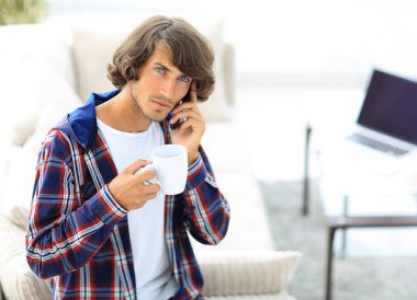 güzel bir fincan adamla bir dizüstü bilgisayar önünde oturur.