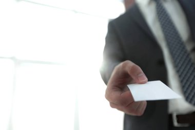 Parlak arka plan üzerinde kartvizit vererek iş adamı