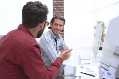 bir masanın arkasında oturan çalışanlar