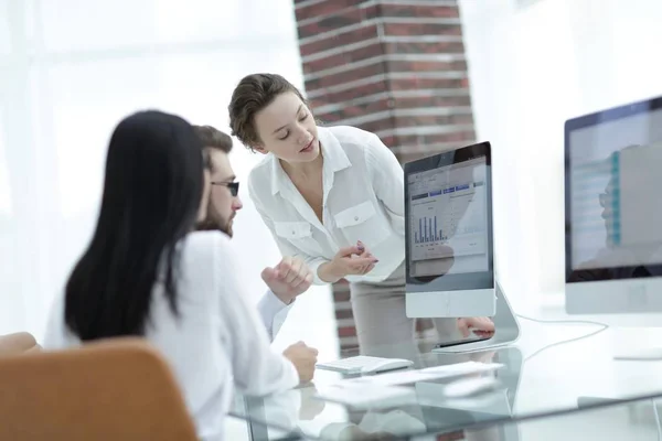 Especialistas de la empresa discutiendo los horarios financieros en el escritorio — Foto de Stock