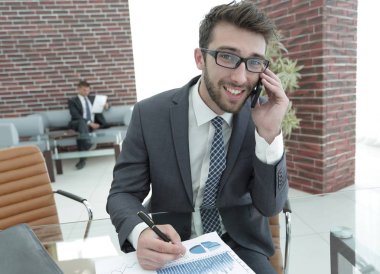 modern ofis akıllı telefonda konuşurken işadamı