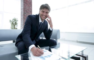 İş yerinde akıllı telefonu olan bir iş adamı.