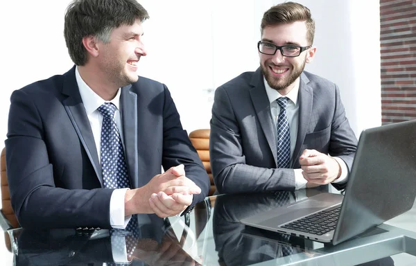 Portrait of two business people sitting at office desk — Stock Photo, Image