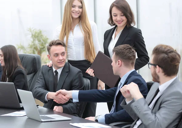 Handshake obchodních partnerů za stolem — Stock fotografie