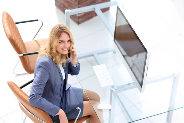 Succesvolle jonge zakenvrouw zitten aan een bureau — Stockfoto