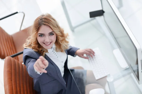 Affärskvinna pekar framåt, sitter bakom ett skrivbord — Stockfoto