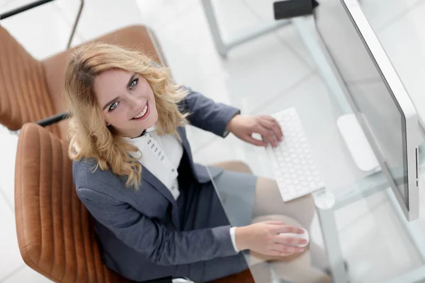Smiling business woman sitting behind a Desk — Stock Photo, Image