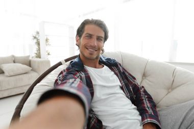 bir sandalyede oturuyor ve elini tutarak kendine güvenen adam.