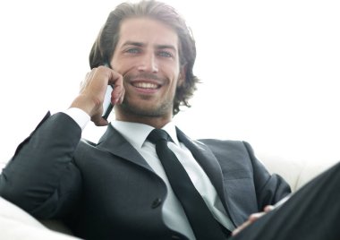 iş adamı rahat bir sandalyede otururken Smartphone'da konuşuyor.