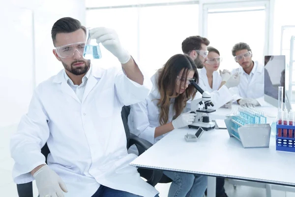 Biokemist med kolven Petri sitter vid ett skrivbord — Stockfoto