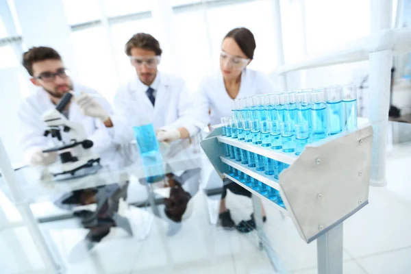 Bakgrundsbild för forskare som studerar blå vätska i en kolv — Stockfoto