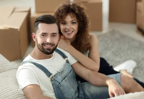 Νεαρό ζευγάρι κάθεται στο πάτωμα σε ένα νέο διαμέρισμα — Φωτογραφία Αρχείου