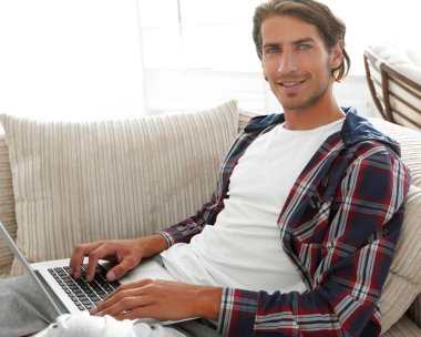 dizüstü bilgisayar ile ciddi genç adam.