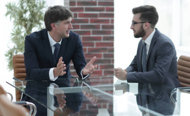 iki işadamı görevleri Office masada oturan tartışıyor.