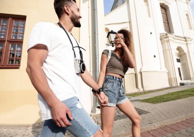 Bir çift şehrin sokaklarında yürüyor ve eğleniyor.