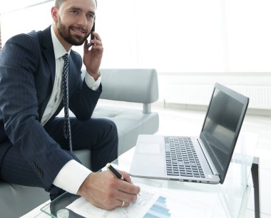 İşadamı Smartphone'da mali grafikler hakkında konuşmak.