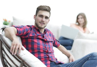 büyük sandalyede oturan genç adam