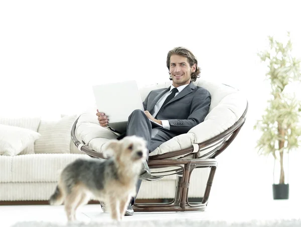 Homme d'affaires moderne avec ordinateur portable assis dans le salon . — Photo