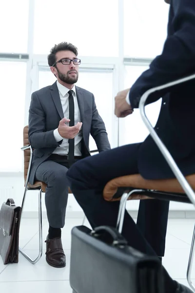 Man sitter på stol i office lyssnar på business affärsman — Stockfoto