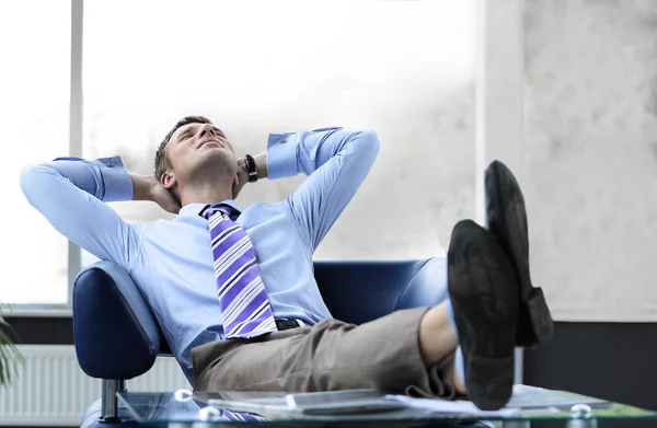 Jeune homme d'affaires penché sur sa chaise — Photo