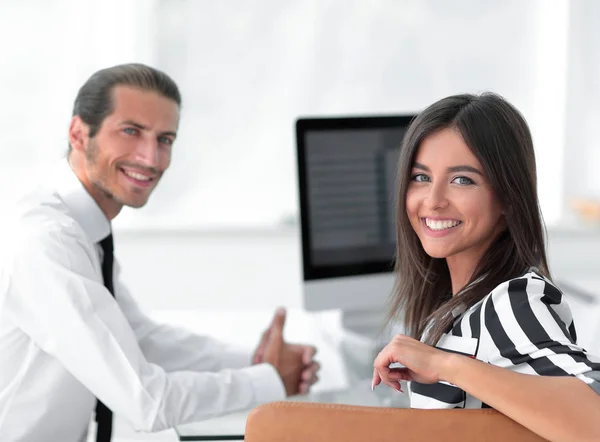 Deux jeunes employés assis derrière un bureau — Photo