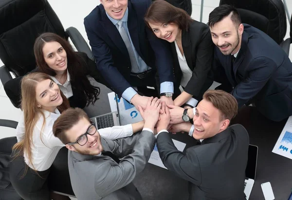 Equipo de negocios con las manos juntas en el escritorio —  Fotos de Stock