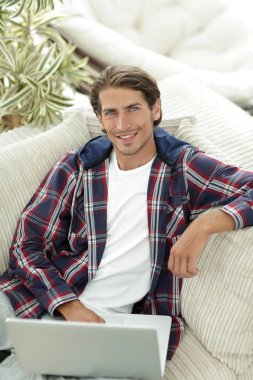 dizüstü bilgisayarda çalışan ve kameraya bakarak başarılı adam. Yukarıdan görüntülemek