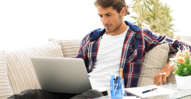 şaşırmış genç adam evden dizüstü bilgisayar ile çalışma.