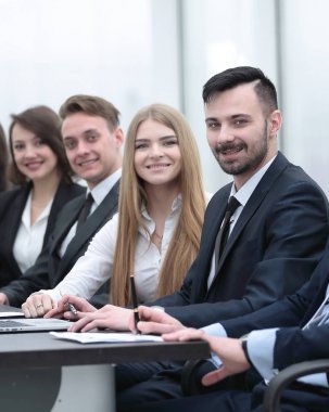 İş ekibi konferans odasındaki masada oturuyor.