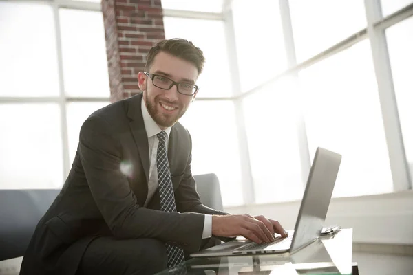 Uomo d'affari con gli occhiali è seduto alla scrivania in ufficio — Foto Stock