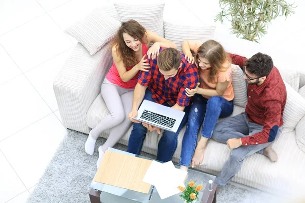 Grupo alegre de amigos olhando para os clipes de vídeo no laptop . — Fotografia de Stock