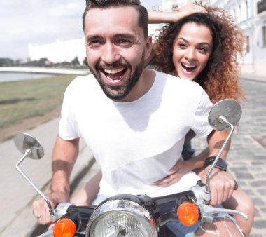 Mutlu çift sürme vintage scooter açık havada.