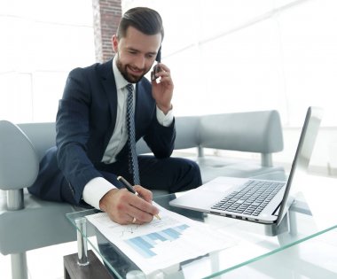 İşadamı Smartphone'da finansal belgeler hakkında konuşmak