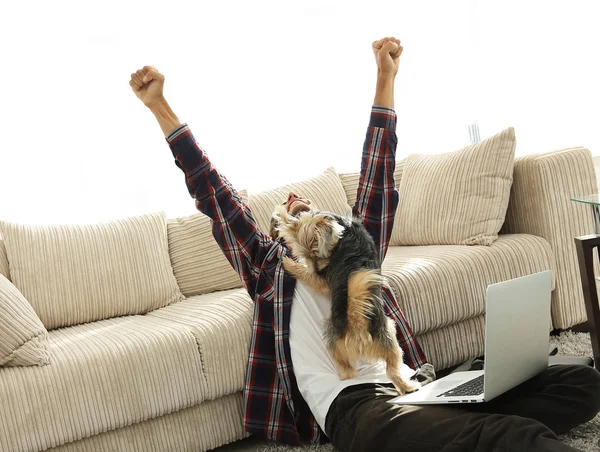 Heureux gars avec son chien assis dans un salon spacieux — Photo