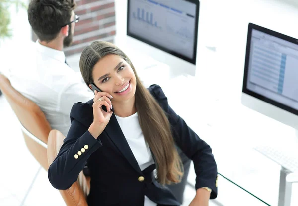 Vrouwelijke werknemer praten op een mobiele telefoon met een klant — Stockfoto