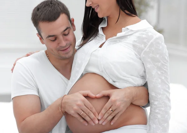 Closeup .husband e mulher grávida colocando as mãos em sua barriga . — Fotografia de Stock