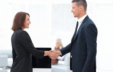 Pazarlık masasında el sıkışan iş ortakları.