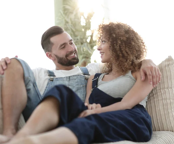 Young couple in work clothes sitting on couch